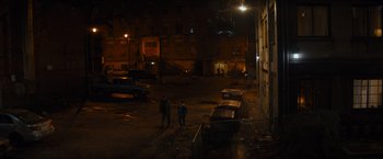 Movie still from “Samaritan” (2022), directed by Julius Avery – Two people standing in the middle of an empty parking lot at night; Extreme Wide shot, High angle