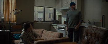 Movie still from “Samaritan” (2022), directed by Julius Avery – A man standing in a kitchen next to a woman; Wide shot, Over the shoulder angle