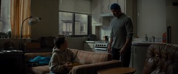 Movie still from “Samaritan” (2022), directed by Julius Avery – A man standing next to a young boy in a kitchen; Medium shot, Over the shoulder angle