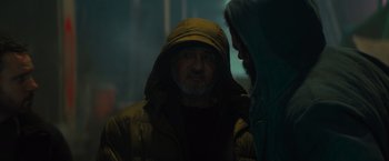 Movie still from “Samaritan” (2022), directed by Julius Avery – A man wearing a yellow jacket and a green hooded jacket; Close Up shot, Over the shoulder angle