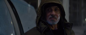 Movie still from “Samaritan” (2022), directed by Julius Avery – A person wearing a hooded jacket; Close Up shot, Over the shoulder angle