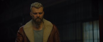 Movie still from “Samaritan” (2022), directed by Julius Avery – A person with a beard wearing a jacket; Close Up shot, Over the shoulder angle