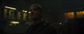 Movie still from “Samaritan” (2022), directed by Julius Avery – An older man with a gray beard looking up at the sky; Close Up shot, Low angle