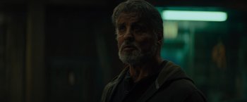 Movie still from “Samaritan” (2022), directed by Julius Avery – An older man with grey hair and a gray beard; Close Up shot, Low angle