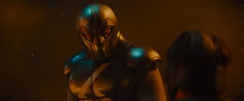 Movie still from “Samaritan” (2022), directed by Julius Avery – A person wearing a metal suit; Medium shot, Over the shoulder angle