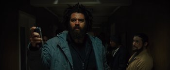 Movie still from “Samaritan” (2022), directed by Julius Avery – A man with a beard is standing in a hallway; Medium shot, Low angle