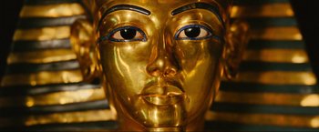 Movie still from “Samsara” (2011), directed by Ron Fricke – A golden statue of an egyptian woman with blue eyes; Extreme Close Up shot, Overhead angle