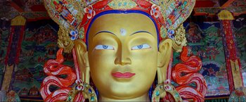 Movie still from “Samsara” (2011), directed by Ron Fricke – The face of a golden buddha statue; Extreme Close Up shot, Low angle