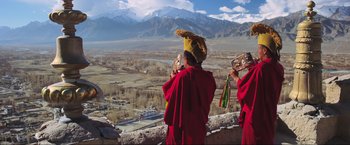 Movie still from “Samsara” (2011), directed by Ron Fricke – Two men in red robes are taking a picture of a valley; Wide shot, Low angle