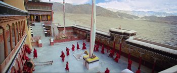 Movie still from “Samsara” (2011), directed by Ron Fricke – A group of people dressed in red are dancing in a courtyard; Extreme Wide shot, High angle