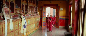 Movie still from “Samsara” (2011), directed by Ron Fricke – A group of young monks walking through a doorway; Wide shot, High angle