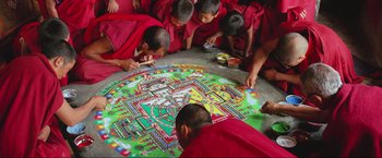 Movie still from “Samsara” (2011), directed by Ron Fricke – A group of young monks working together on a mandala; Extreme Wide shot, Overhead angle