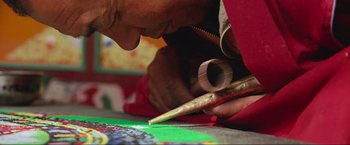 Movie still from “Samsara” (2011), directed by Ron Fricke – A man is painting a picture on the floor; Extreme Close Up shot, High angle