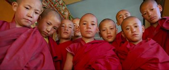 Movie still from “Samsara” (2011), directed by Ron Fricke – A group of young boys in red robes; Close Up shot, Low angle