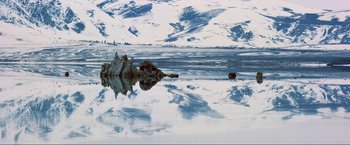 Movie still from “Samsara” (2011), directed by Ron Fricke – A body of water that has a rock in it; Extreme Wide shot, High angle