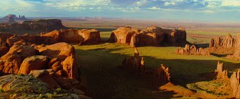 Movie still from “Samsara” (2011), directed by Ron Fricke – A view of a desert landscape with rocks in the foreground; Extreme Wide shot, High angle