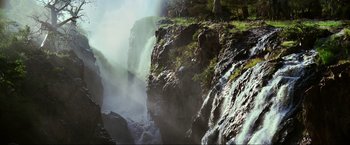Movie still from “Samsara” (2011), directed by Ron Fricke – A view of a waterfall from the side of a cliff; Extreme Wide shot, High angle