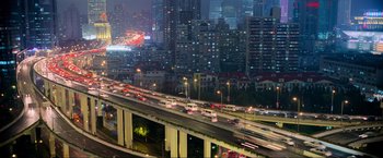 Movie still from “Samsara” (2011), directed by Ron Fricke – A busy highway with a bunch of cars on it at night time; Extreme Wide shot, High angle