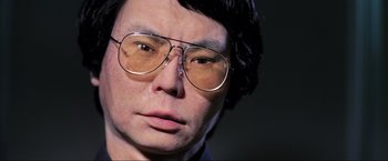 Movie still from “Samsara” (2011), directed by Ron Fricke – A person wearing glasses; Extreme Close Up shot, Over the shoulder angle