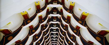 Movie still from “Samsara” (2011), directed by Ron Fricke – A view of a room from the top of the stairs; Extreme Wide shot, Overhead angle