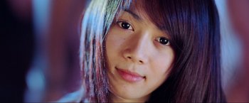 Movie still from “Samsara” (2011), directed by Ron Fricke – A young woman's face with purple hair; Extreme Close Up shot, Low angle