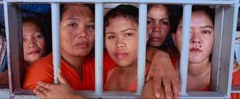 Movie still from “Samsara” (2011), directed by Ron Fricke – A group of women behind a metal fence; Close Up shot, High angle