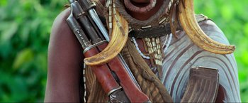 Movie still from “Samsara” (2011), directed by Ron Fricke – A banana peel is sitting on top of a rifle; Extreme Close Up shot, Low angle