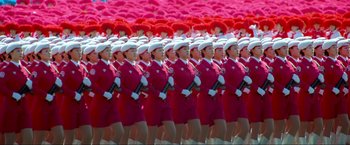 Movie still from “Samsara” (2011), directed by Ron Fricke – A group of women in red and white uniforms; Extreme Wide shot, High angle