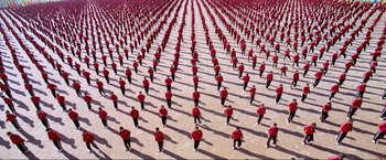 Movie still from “Samsara” (2011), directed by Ron Fricke – A large group of people standing in a field; Extreme Wide shot, High angle
