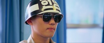 Movie still from “Samsara” (2011), directed by Ron Fricke – A young man wearing sunglasses and a helmet; Close Up shot, Low angle