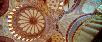 Movie still from “Samsara” (2011), directed by Ron Fricke – The ceiling of a building has a pattern on it's walls; Extreme Wide shot, Low angle