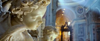 Movie still from “Samsara” (2011), directed by Ron Fricke – A statue of a boy and a girl in a building; Extreme Close Up shot, Low angle