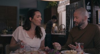 Movie still from “Big Time Adolescence” (2019), directed by Jason Orley – Two people sitting at a dinner table talking to each other; Medium shot, Over the shoulder angle