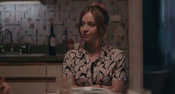 Movie still from “Big Time Adolescence” (2019), directed by Jason Orley – A woman sitting at a table in front of plates; Close Up shot, Over the shoulder angle