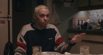 Movie still from “Big Time Adolescence” (2019), directed by Jason Orley – A man sitting at a table with a glass of water; Close Up shot, Over the shoulder angle