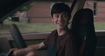 Movie still from “Big Time Adolescence” (2019), directed by Jason Orley – A young man sitting in the driver's seat of a car; Close Up shot, Over the shoulder angle