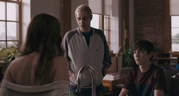 Movie still from “Big Time Adolescence” (2019), directed by Jason Orley – A man standing in front of two other people; Medium shot, Over the shoulder angle