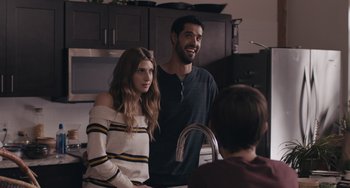 Movie still from “Big Time Adolescence” (2019), directed by Jason Orley – A man and a woman standing in a kitchen next to a sink; Medium shot, Over the shoulder angle