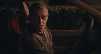 Movie still from “Big Time Adolescence” (2019), directed by Jason Orley – A person sitting in a car at night looking out the window; Close Up shot, Over the shoulder angle