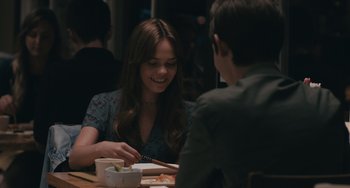 Movie still from “Big Time Adolescence” (2019), directed by Jason Orley – A woman sitting at a table with a plate of food in front of a man; Medium shot, Over the shoulder angle