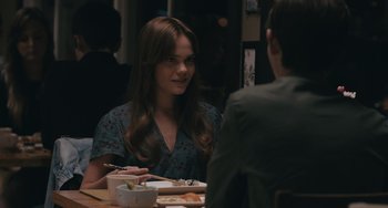 Movie still from “Big Time Adolescence” (2019), directed by Jason Orley – A woman sitting at a dinner table with a man; Close Up shot, Over the shoulder angle