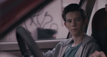 Movie still from “Big Time Adolescence” (2019), directed by Jason Orley – A man sitting in the driver's seat of a car; Close Up shot, Over the shoulder angle