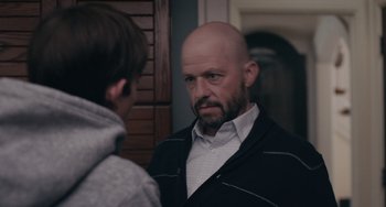 Movie still from “Big Time Adolescence” (2019), directed by Jason Orley – A man with a shaved head is looking at a boy; Close Up shot, Over the shoulder angle