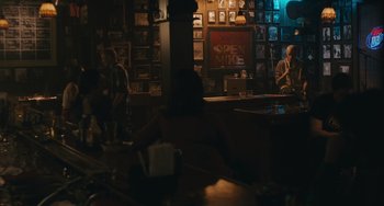 Movie still from “Big Time Adolescence” (2019), directed by Jason Orley – People are sitting at a bar in the dark; Wide shot, Over the shoulder angle