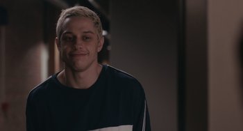 Movie still from “Big Time Adolescence” (2019), directed by Jason Orley – A man with blonde hair is smiling for the camera; Close Up shot, Over the shoulder angle