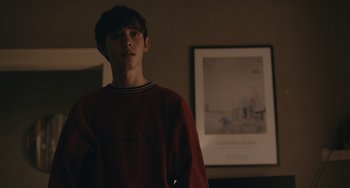 Movie still from “Big Time Adolescence” (2019), directed by Jason Orley – A young man standing in front of a painting; Medium shot, Over the shoulder angle