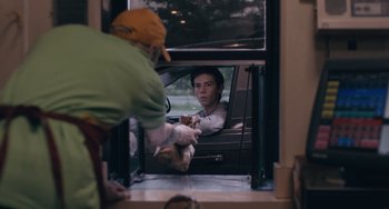 Movie still from “Big Time Adolescence” (2019), directed by Jason Orley – A person in a car getting food out of the window; Medium shot, Over the shoulder angle