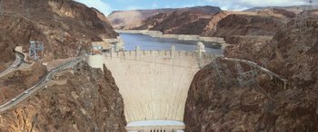Movie still from “San Andreas” (2015), directed by Brad Peyton – A view of a dam with a lake and mountains in the background; Extreme Wide shot, High angle