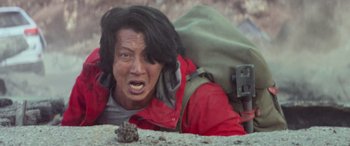 Movie still from “San Andreas” (2015), directed by Brad Peyton – A person with a backpack is laying on the ground; Close Up shot, High angle