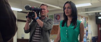 Movie still from “San Andreas” (2015), directed by Brad Peyton – A man and a woman standing next to each other holding a video camera; Medium shot, Over the shoulder angle